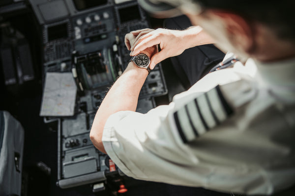 A pilot setting time on wrist watch