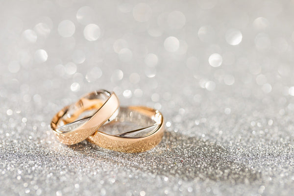 golden wedding rings on glitter background
