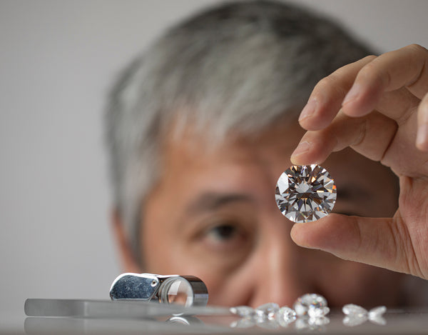 Man jeweller carefuly examining diamond